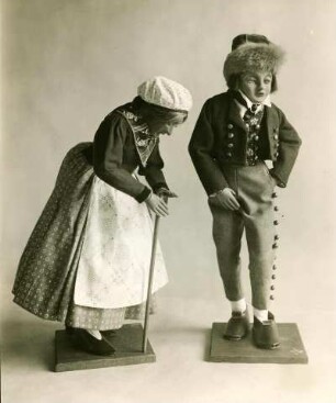 Zwei Spielfiguren in handgefertigter Stoffbekleidung, Alte Dame mit Gehstock, gestützt. Grenzstrich Elsaß, Halbtotale