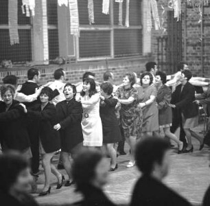 Nachbarschaftspolonaise : Hohburg. Männer und Frauen die in einer geschmückten Mehrzweckhalle eine große Polonaise tanzen
