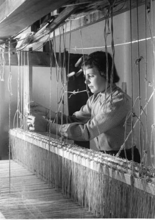 Eine Weberin arbeitet traditionell an einem Handwebstuhl. Aufgenommen 1940