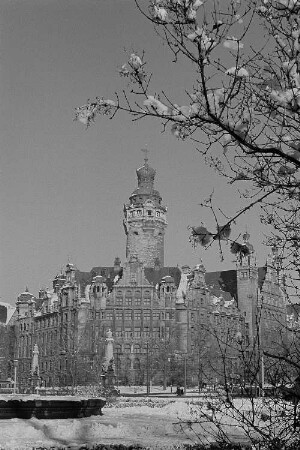 Winter in Leipzig, Blick auf das neue Rathauses, im Vordergrund die verschneiten Äste eines Baumes