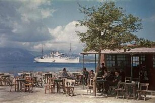 Reisefotos Griechenland. Strandcafé und vor der Küste ankerndes Passagierschiff "Milwaukee" (vielleicht im Mittelmeer)