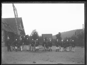 Anstaltsfeuerwehr mit Leiter und Spritzschlauch vor dem Feuerwehrgerätehaus; im Hintergrund Krankengebäude F5 und F4 und Kesselhaus