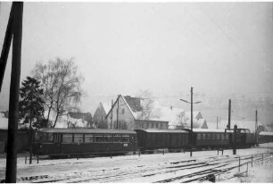 Gammertingen, blaue Diesellok V 500 und roter MAN-Triebwagen, Packwagen und Personenwagen von 1908, Bahnhofstraße 2 erbaut 1939, Abbruch 1983, seitdem Parkplätze