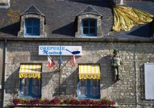 Frankreich. Basse Normandie. Manche. Sainte Marie du Mont. GI Steele als Werbung fuer einer Creperie