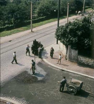 Dresden-Leutewitz. Straßenbauarbeiten Auf der Scheibe Ecke Warthaer Straße, Herstellen einer Einstreudecke (Splitt) auf bituminösen Bindemittel, aufgebracht mit Bitumenspritzmaschine