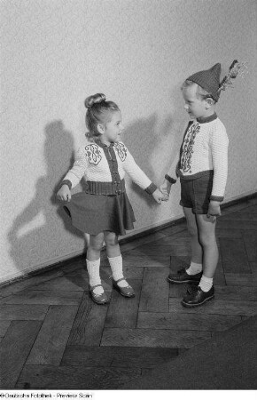 Ein Junge und ein Mädchen präsentieren Kinderbekleidung