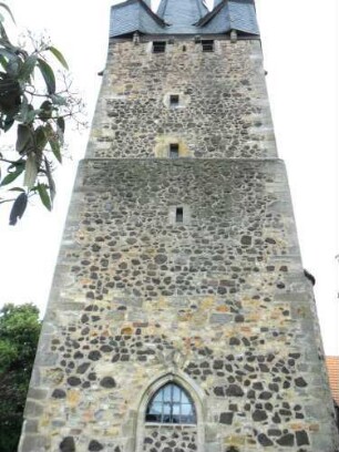 Evangelische Kirche - Kirchturm (frühgotisch 13 Jhd) von Westen mit Schießscharten in den Mittelgeschossen sowie Werksteinen im Mauersteinverband