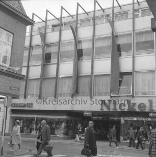 Kaufhaus Nickel: Mühlenstraße: Neubau mit Schaufensterfront und Werbebannern: davor Fußgänger: vorn Einmündung der Hindenburgstraße