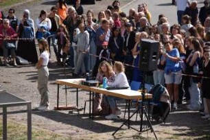 Bad Oldesloe: Kindervogelschießen: Exer: Schießstand für die Mädchen: Kommentatorinnentisch, daneben Teilnehmerin: im Hintergrund Zuschauer: 13. Juli 2023