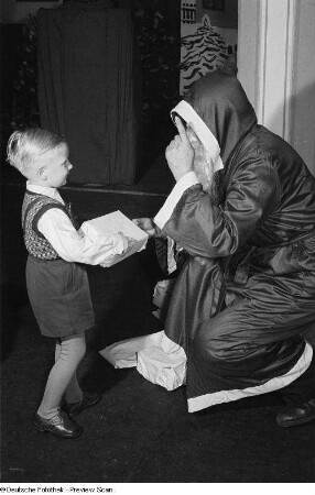 Weihnachtsmann beim Überreichen von Geschenken an Kinder auf der Weihnachtsfeier des VEB Kartographie
