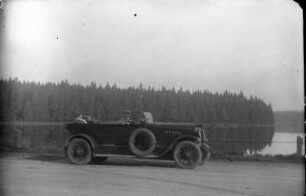 Harz? Personenkraftwagen vom Typ Ford (?) mit offenem Verdeck auf einer Straße an einem See
