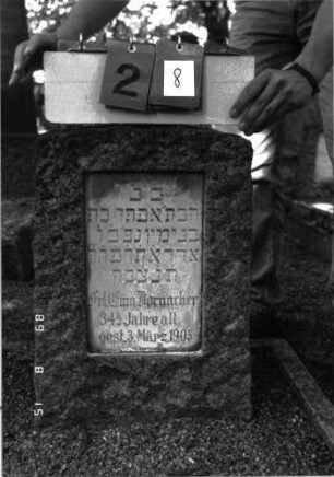 Grabstein 28 (Index: 100105458) Material: Granit, weiße Marmorplatte Zustand: gut Maße HxBxT: 51x35x26 cm Beschreibung: Stele, flacher Segmentbogenabschluß, rechteckige Schriftplatte: Grabstein 28
