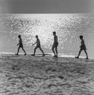 Jugendliche laufen am Strand entlang