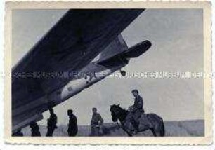 Deutsche Soldaten unter dem Heck eines abgestürzten sowjetischen Bombenflugzeuges
