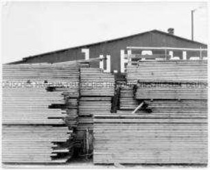 Holzstapel vor einer großen Halle