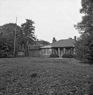 Am Bondenholz: Lunugala [ehemaliger Jugendhof]: Blick vom Park auf Gebäudeensemble: vorn Gruünfläche: hinten auf Veranda Leiter: links Fahnenmast: hinten rechts und links Bäume