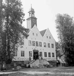 Herrenhaus: Restaurierungsarbeiten an Nordportal und Treppe: davor Baumaterial: links zwei Männer auf Auffahrt: vorn Rasenfläche: rechts und links Bäume