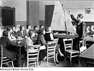Lehrerin erklärt einer Mädchenklasse den Aufbau eines Segelbootes