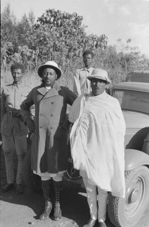 Oberhäupter der Amhara : Zwei Oberhäupter der Amhara vor einem Lastkraftwagen. Im Hintergrund italienische Kolonialsoldaten.
