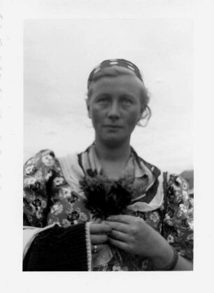 Hildegard Ostkamp-Blumer (1909-2001; Sopranistin), Ehefrau des Komponisten Theodor Blumer (1881-1964), in Wanderbekleidung mit Blumensträußchen (auf einem Wanderweg zur Breitach im Kleinwalsertal). Fotografie, Juli 1938