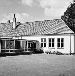 Volksschule: links Anbau: davor Schulhof: hinten rechts Baum