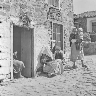 Griechenland. Insel Limnos. Vor dem Anwesen wird Baumwolle verabeitet und gesponnen.