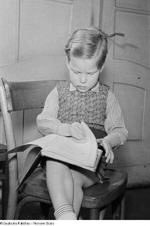 Porträt eines kleinen Jungen beim Lesen eines Buchs