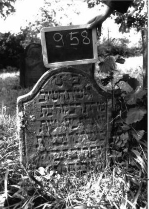 Grabstein 958 (Index: 100103872) Material: Sandstein Zustand: teilweise stark verwittert Maße HxBxT: 60x45x7 cm Beschreibung: Stele mit Konvexbogenabschluss, Schriftfeld durch umlaufende Rille abgeteilt: Grabstein 958