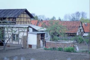 Blick über Gärten auf Wirtschaftsgebäude