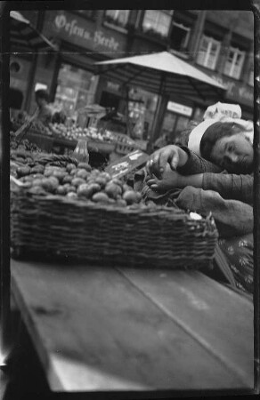 Schlafende Marktfrau an einem Verkaufsstand für Kartoffeln