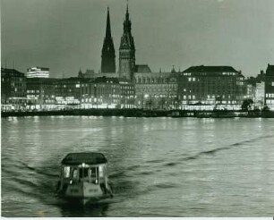 Hamburg-Altstadt bei Nacht. Blick von der Lombardsbrücke über die Binnenalster Richtung Jungfernstieg. Im Hintergrund die Türme des Hamburger Rathauses und des Mahnmales der Kirche St. Nikolai