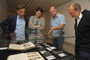 SLUB, Ausstellung "Gespräche mit der Erde. Geowissenschaften in Sachsen" : Ausstellungseröffnung am 14. Oktober 2014 im Vortragssaal. Gäste an einer Ausstellungsvitrine im Buchmuseum