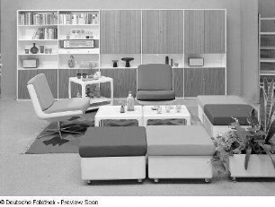 Drehstuhl : Möbelprogramm "variopur" (1973; VEB Petrolchemisches Kombinat Schwedt). Vier Hocker und zwei Drehstühle mit zwei Beistelltischen, Barwagen und Blumenkasten vor Anbauwand