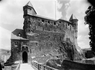 Blick von der Vorburg zur Schildmauer von Burg Stahleck, mit überdachtem Wehrgang, rechts der "Froschteich"