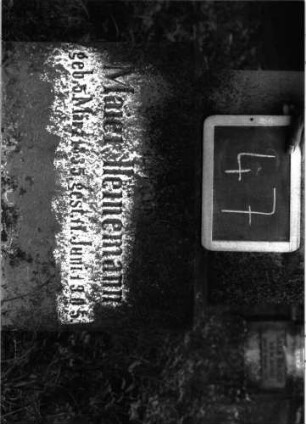 Grabstein 47 (Index: 100101023) Material: Sandstein, neue schwarze Platte Zustand: Schrifttafel fehlt, Sockel verwittert Maße HxBxT: 160x45x21 cm Beschreibung: Stele, Sockel, Abdeckplatte mit rechteckigem Aufsatz und seitlichen Voluten, eingetieftes Schriftfeld rechteckig Symbolik: Voluten Besonderheit: eingemeißelte Nummer: 34: Grabstein 47A