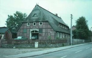 Dorfstraße 10: Schullandheim: traufständiges Fachwerkhaus mit Reetdach: Giebelseite Wirtschaftstrakt mit ehemaligem Scheunentor: Straßenfront mit breiter Dachgaube