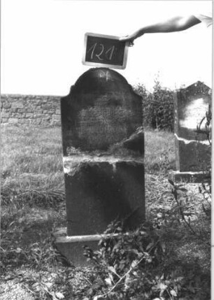 Grabstein 121 (Index: 100114153) Material: Kalkstein Zustand: zweifach gebrochen und repariert Maße HxBxT: 117x47x15 cm Beschreibung: Stele, Sockel, Konvexbogenabschluß: Grabstein 121