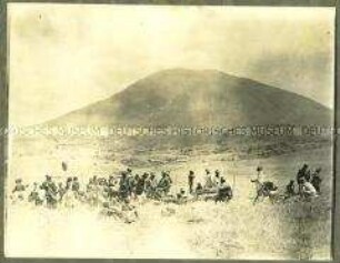 Gruppe von Askaris und Trägern bei einer Rast in der Steppe
