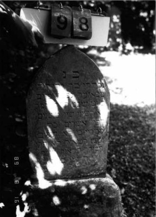 Grabstein 98 (Index: 100086584) Material: Sandstein Zustand: verwittert Maße HxBxT: 88x33x6 cm Beschreibung: Stele, Sockel, Spitzbogenabschluß Besonderheit: Kindergrab: Grabstein 98