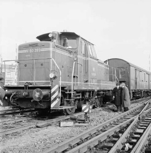 Bahnunfall: Bahnhof Bad Oldesloe: beim Rangieren entgleiste Rangierlokomotive auf Weiche: vorn Gleise: rechts Bahnarbeiter und zwei Männer neben Lokomotive: hinten links Signalanlage und Schranke: dahinter Wohnhaus