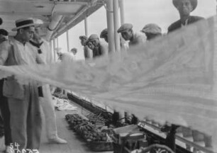 Souvenirhändler : Ein Händler an Bord des Dampfers zeigt seine Waren