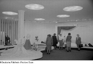 Besucherinnen an Messeständen mit Oberbekleidung (Abendkleider)