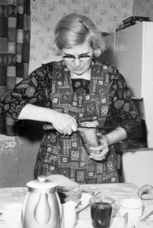 Frau beim Brotschneiden