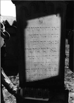 Grabstein 184 (Index: 99797616) Material: Sandstein, weiß Zustand: leicht verwittert Maße HxBxT: 193x66x20 cm Beschreibung: Stele, Giebel rechteckig erhöht, getreppter Sockel Symbolik: Blüten, Rundbogenfries: Grabstein 184A