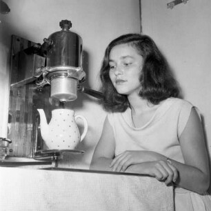 Junge Frau neben einem Kaffee- oder Teeautomat