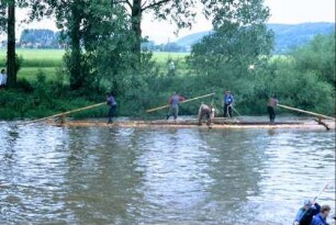 Flößer fahren mit einem Floß die Saale hinab