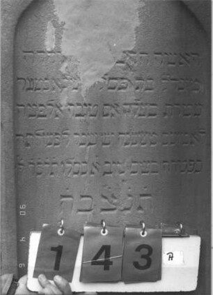 Grabstein 143 (Index: 99608827) Material: Sandstein Zustand: beschädigt mit kleinem Textverlust Maße HxBxT: 131x58x22 cm Beschreibung: Stele, getreppter Rustikasockel, getreppter giebelaritger Abschluß, Schriftfeld eingetieft mit Spitzbogenabschluß: Grabstein 143A