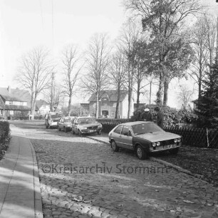 Kirchenweg: Polizei: Verkehrskontrolle: am Straßenrand rechts und hinten Polizeiauto und mehrere Pkw: rechts hinter Pkw Polizist und Fahrer: vorn Kopfsteinpflaster