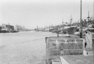 Hafen : Blick von einer Kaimauer in einen Hafen mit Schiffen