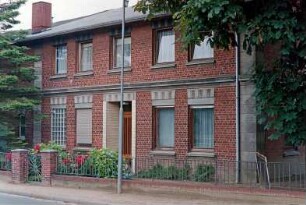traufständiges Bauernhaus aus Backstein: Straßenfront mit Eingangstür, Glasbausteinfenster: Vorgarten, Gartenzaun, Pforte